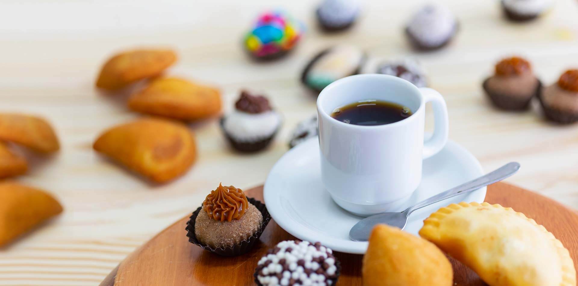 Docinhos e salgados com uma xícara de café da Confeitaria Helena